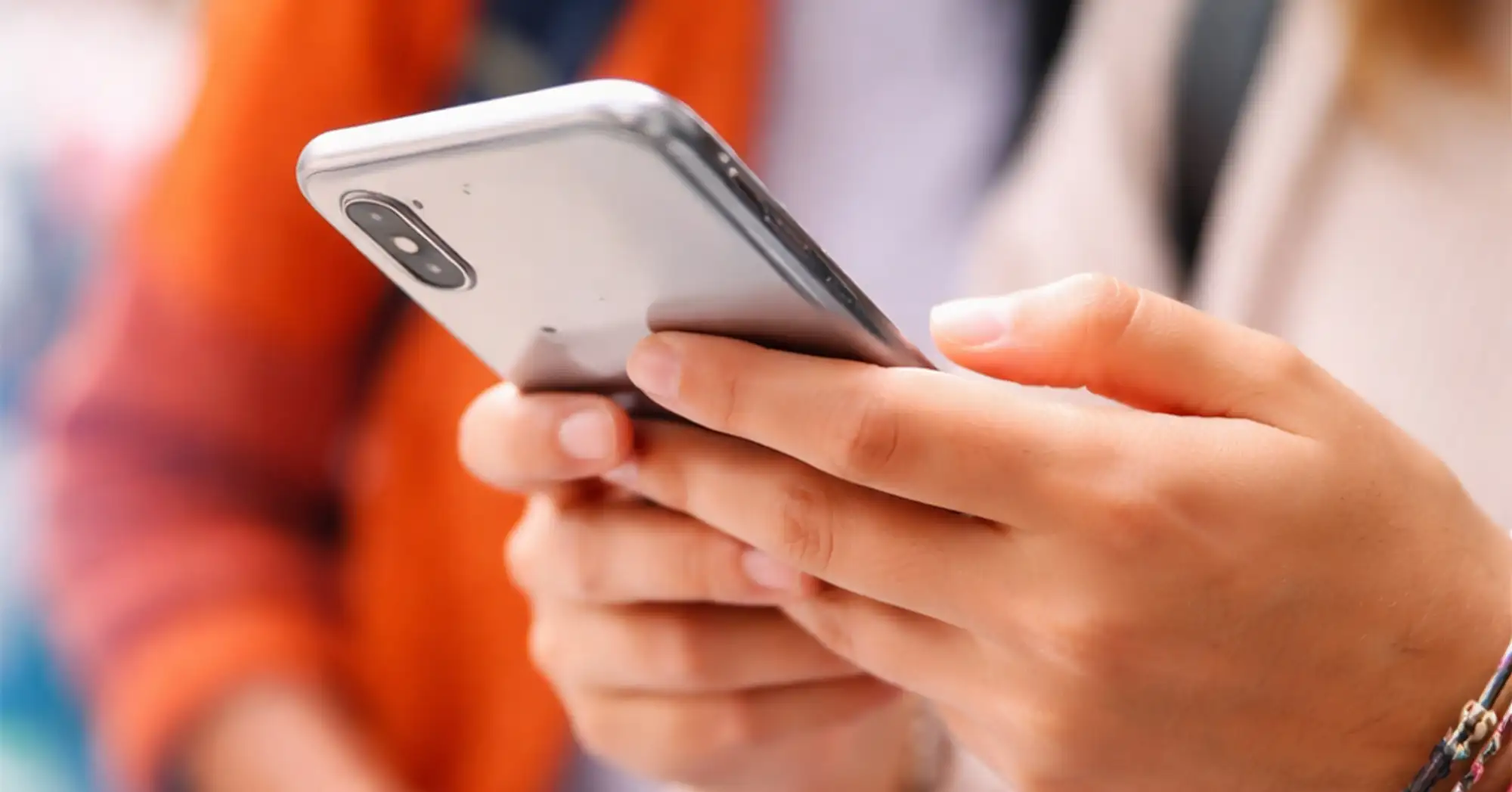detail of a young person holding a smartphone in their hands